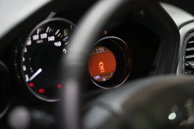 Close up of fuel guage and speedometer through the steering wheel of car