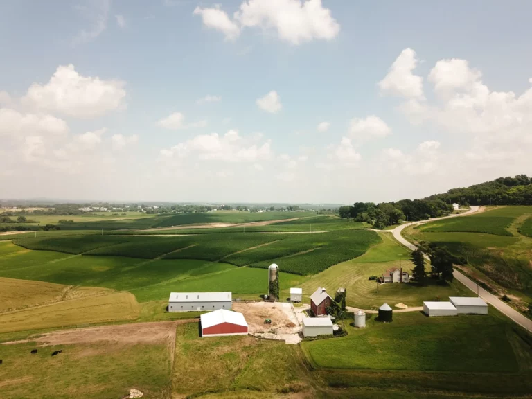 Bird’s eye view shot of white and brown house surrounded by green grass field
